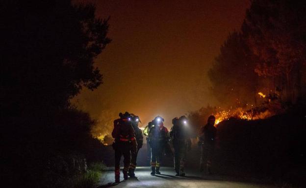 Varios bomberos forestales trabajan en la extinción del incendio de Cures, en Boiro. 