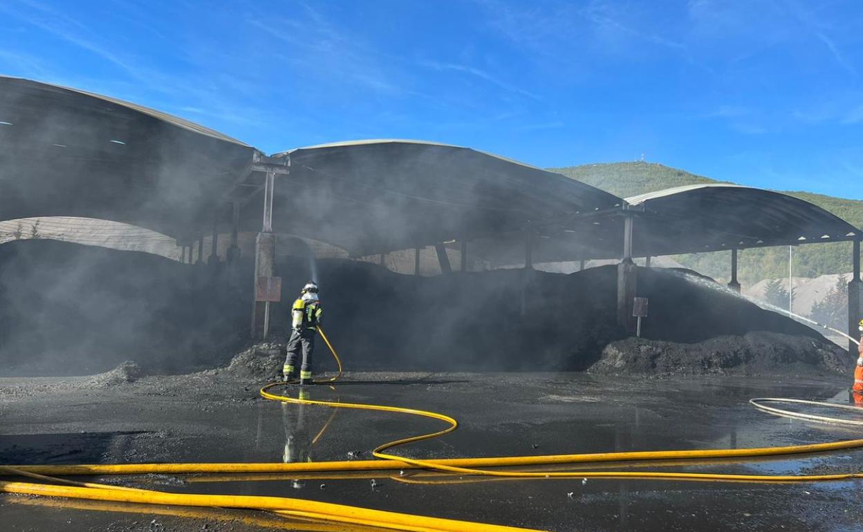 Una pila de gomas ha provocado un incendio en la fábrica de cementos de La Robla. En la imagen, los efectivos de Bomberos León trabajan en el área en la que se ha producido el fuego. 