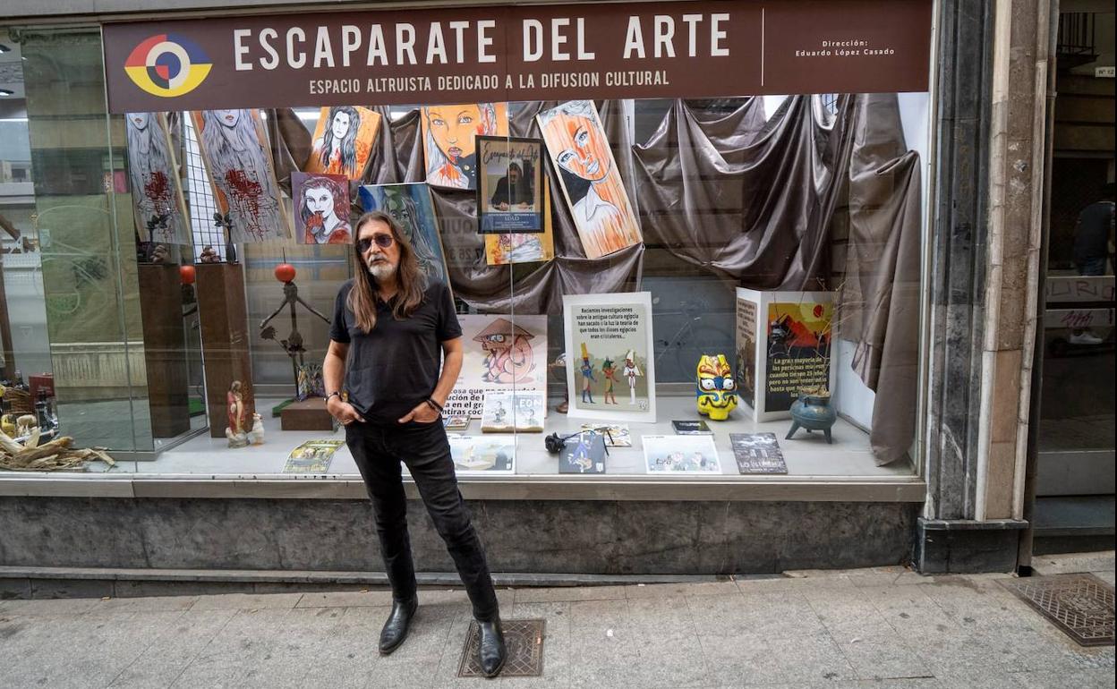 El dibujante leonés Lolo posando frente al escaparate del arte situado en un ventanal de La Casa del Embutido, en la calle Conde Rebolledo esquina con la Rúa. 