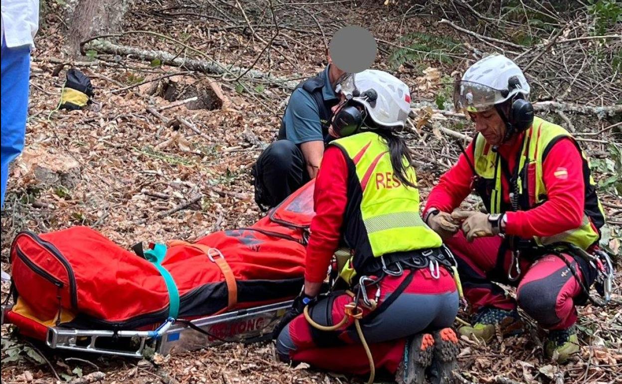 El grupo de rescate de Protección Civil rescata al hombre que había resultado herido al caerle un tronco mientras cortaba leña en Corullón.