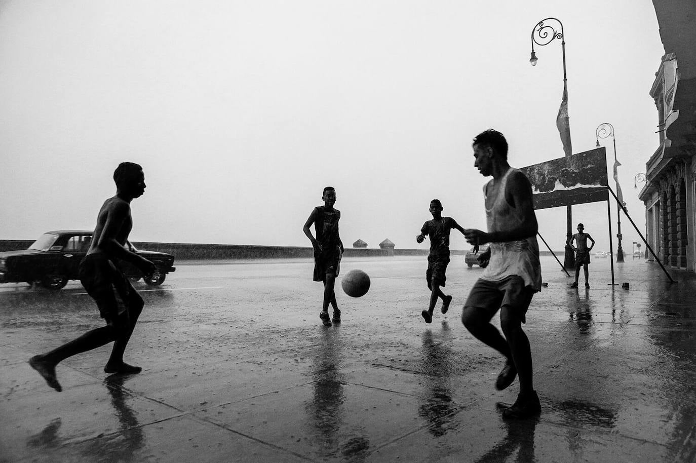 La imagen de Moník, de niños jugando fútbol pick-up en las calles mojadas del Malecón de La Habana