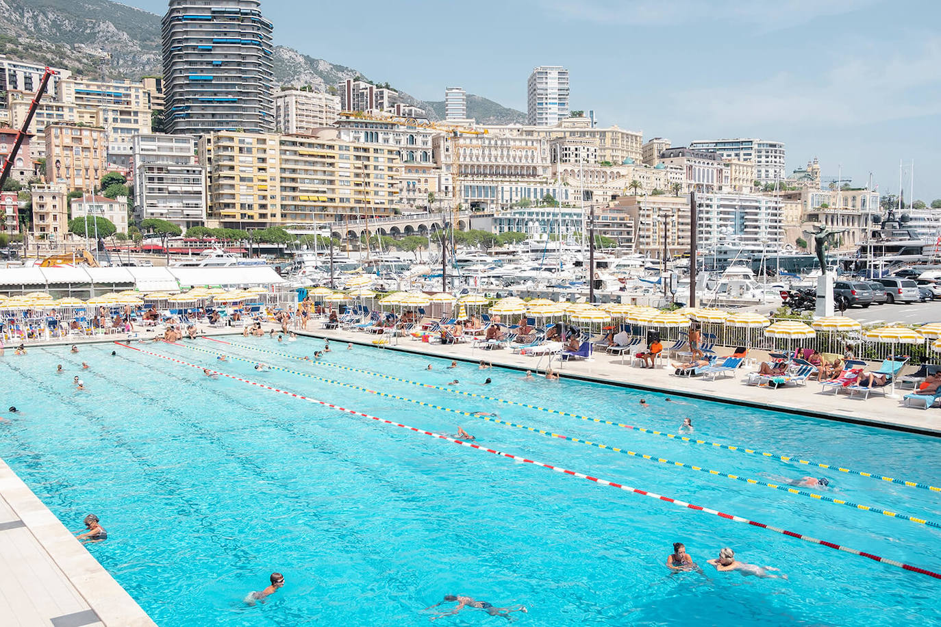 Para muchos, viajar es sinónimo de relajación y esta piscina azul agua ofrece un escape acogedor, así como un rincón de tranquilidad entre el caos de bloques de apartamentos, grúas, yates, líneas eléctricas y sombrillas.