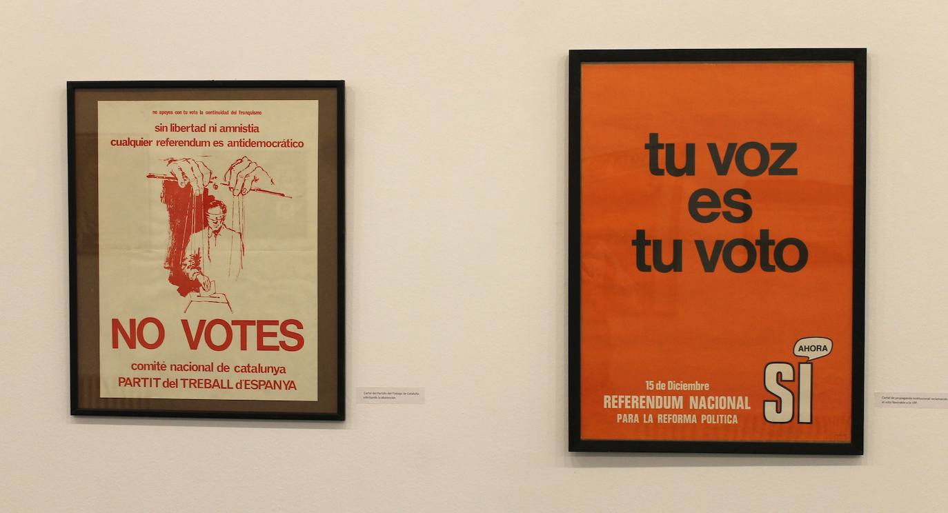 Miguel Gutiérrez psoa con algunos de los carteles que se pueden observar en la exposición.