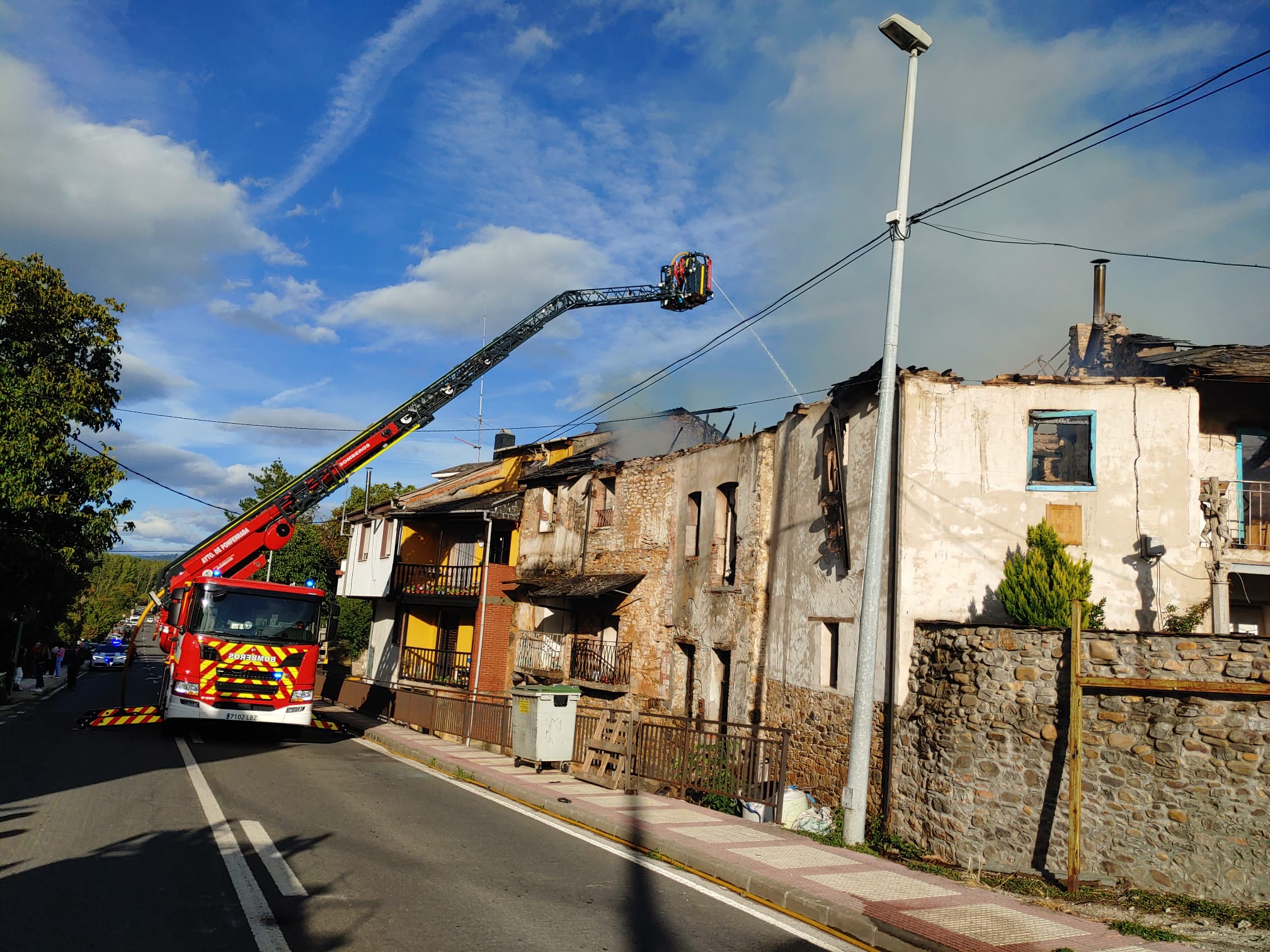 Los Bomberos de Pofnerrada trabajan en la extinción de un intenso fuego que se originaba en una casa de Villalibre y de lque todavía se desconocen sus causas