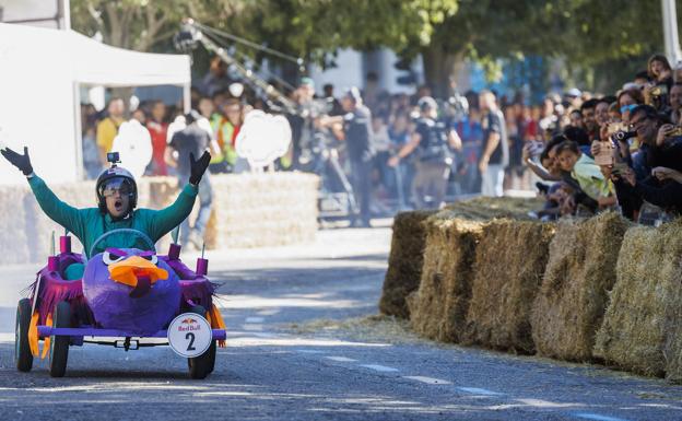 Imagen principal - Un participante en el descenso en la carrera de autos locos; dos competidores en el 'paddock' antes de la carrera.