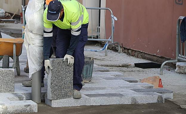 Instalación de los adoquines de granito que formarán parte de las aceras de la avenida de los Cubos. 