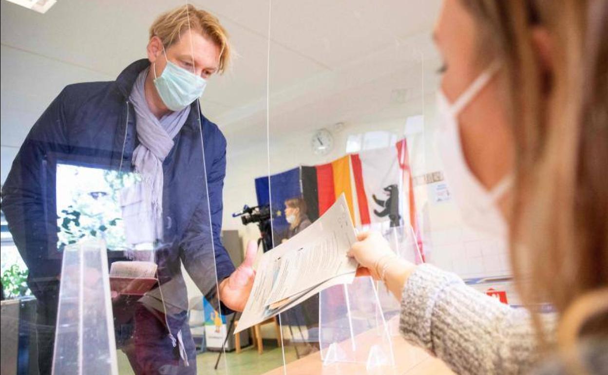 Un hombre recibe las papeletas para votar en un colegio electoral de Berlín el 26 de septiembre de 2021.