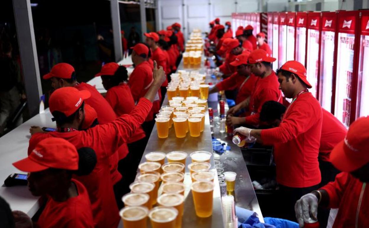 Trabajadores cataríes sierven cerveza en la fiesta de apertura de la 'Fan Zone' de la FIFA en Qatar. 