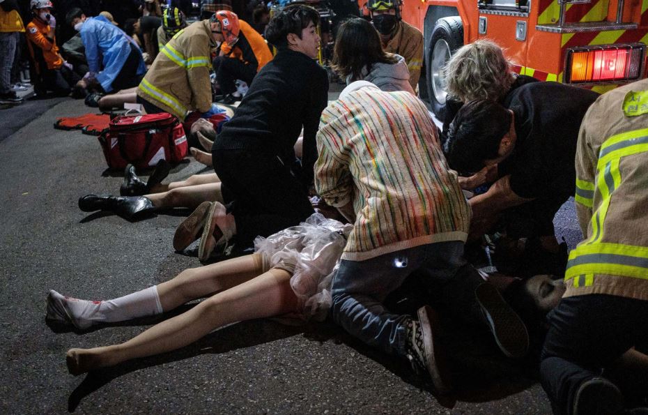 Los equipos de emergencia y otras personas ayudan a las personas que quedaron atrapadas en una estampida de Halloween en en Seúl, el 29 de octubre. Más de 150 personas murieron. 