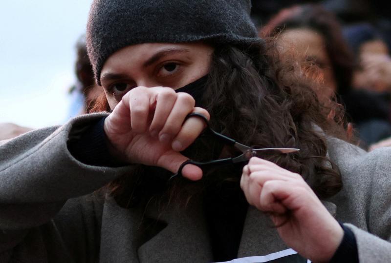 Una joven iraní se corta un mechón de su cabello en desafío al régimen durante una manifestación en protesta por la muerte de Masha Amini