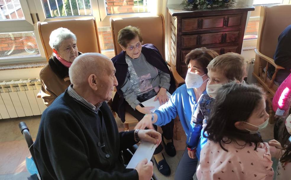 Los alumnos del Colegio 'Paula Montal' de Astorga visitan las residencias de ancianos dentro del proyecto 'Una postal, una sonrisa'.