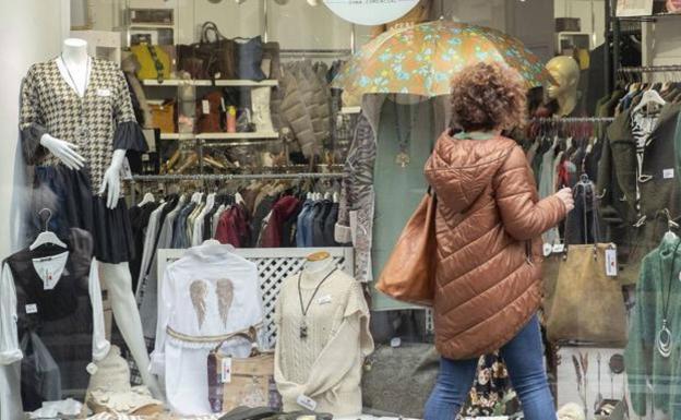 Una mujer frente a un escaparate de un comercio.