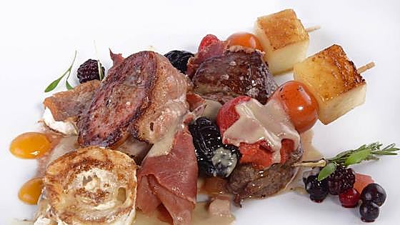 Brocheta de cerdo con jamón,melón asado y ciruela pasa con queso de cabra