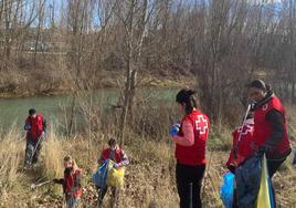 Los voluntarios de Cruz Roja durante la acción en el río Torío en La Candamia.