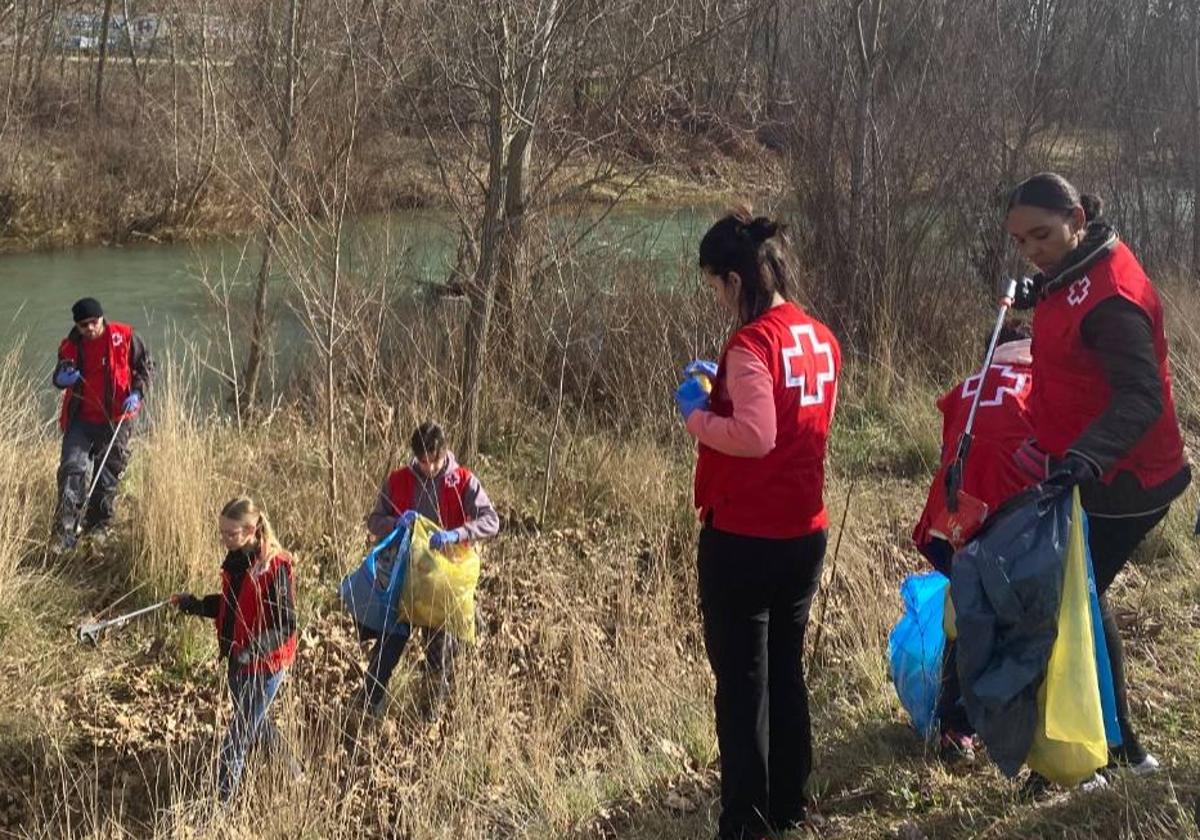 Los voluntarios de Cruz Roja durante la acción en el río Torío en La Candamia.