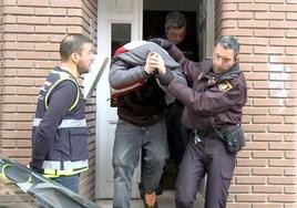 El acusado de matar a su madre en León es escoltado por la policía tras proceder al registro de su domicilio.