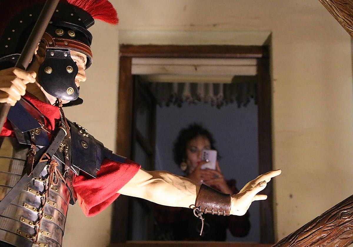 Una mujer se asoma a la ventana al paso de la Procesión de la Virgen de la Amargura.