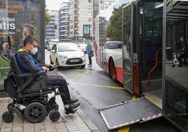 Un usuario en silla de ruedas sube a un autobús en Asturias.