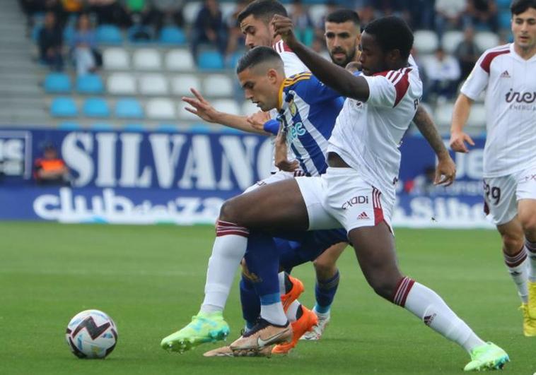 Edu Espiau pugna por un balón con dos futbolistas del Albacete.