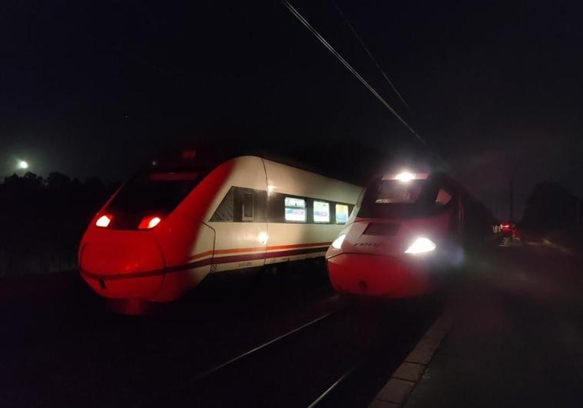 Un tren S-121 de los que cubren la ruta Gijón-Valladolid y otro S-730 que suele prestar el servicio Alvia, a punto de iniciar la circulación en paralelo hacia la variante de Pajares desde la estación de Santibáñez, en la noche del sábado al domingo.