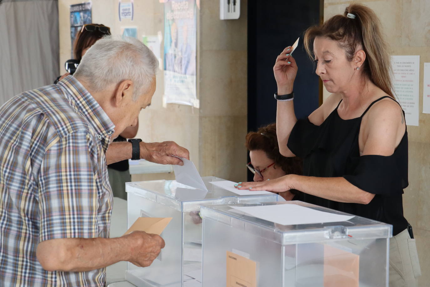 Una hombre depositando su voto en la urna.