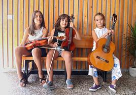 Tres jóvenes esperan para acudir a una de sus clases del campus.