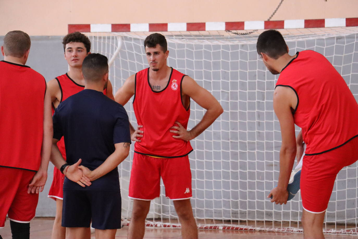 Los jugadores atienden al preparador físico culturalista.