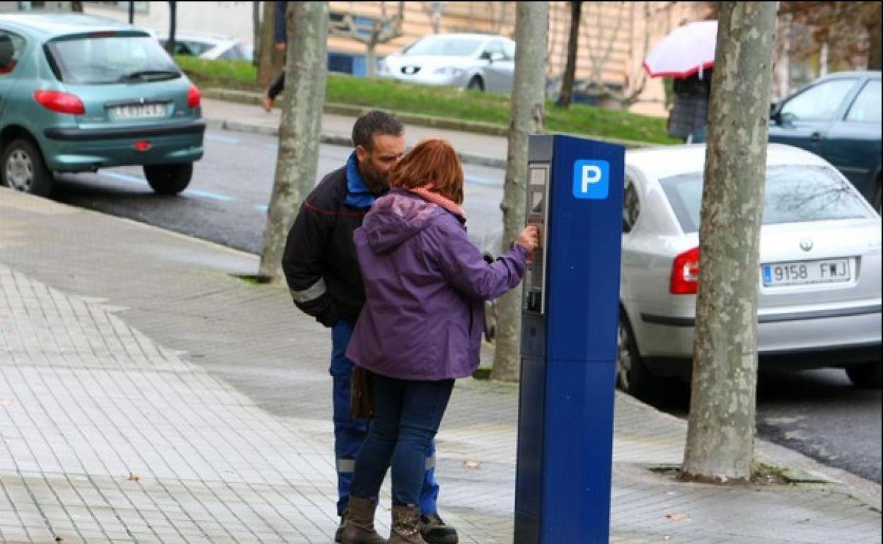 Dos usuarios hacen uso del parquímetro en la capital.