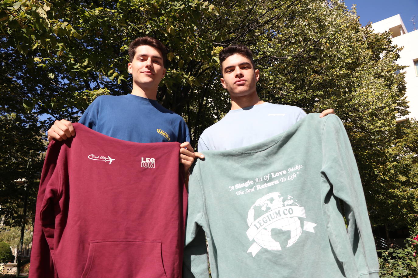 Arturo y Luis con dos de las sudaderas de su marca.