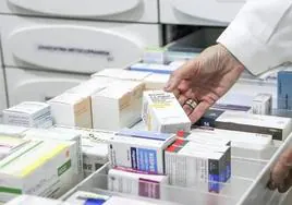 Un profesional farmacéutico sostiene un medicamento.