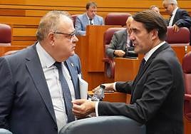 El consejero de Sanidad Alejandro Vázquez conversa con el consejero de Medio Ambiente Juan Carlos Suárez Quiñones en el pleno de las Cortes.