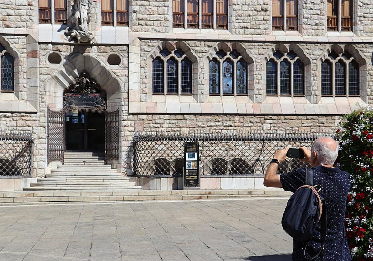Un hombre hace una foto de Casa Botines.