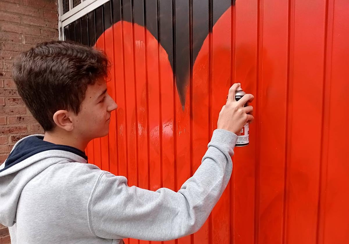 Un estudiante de Maristas restaura la puerta del garaje vandalizado.
