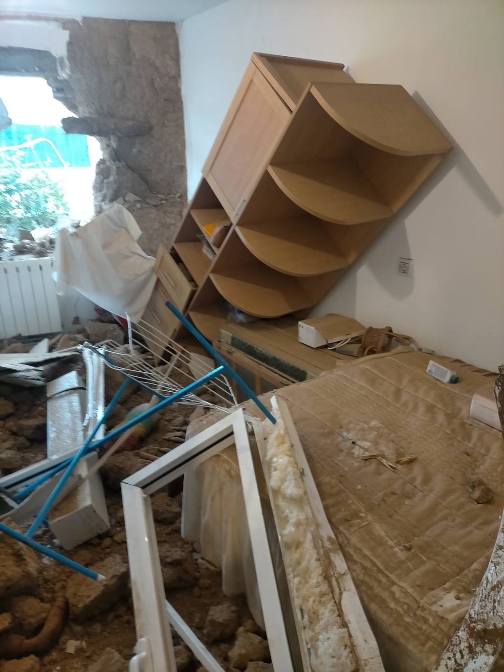 La estantería que estaba al lado de la pared cae tras el accidente