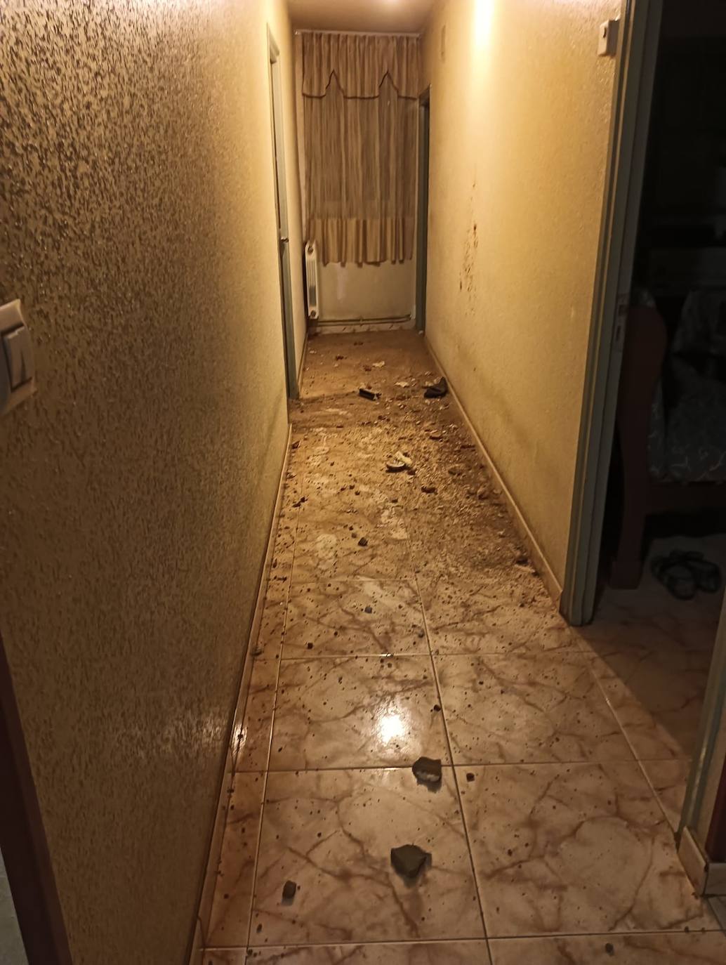 La fuerza del golpe llevó restos de adobe, tierra y polvo al pasillo de la vivienda. 