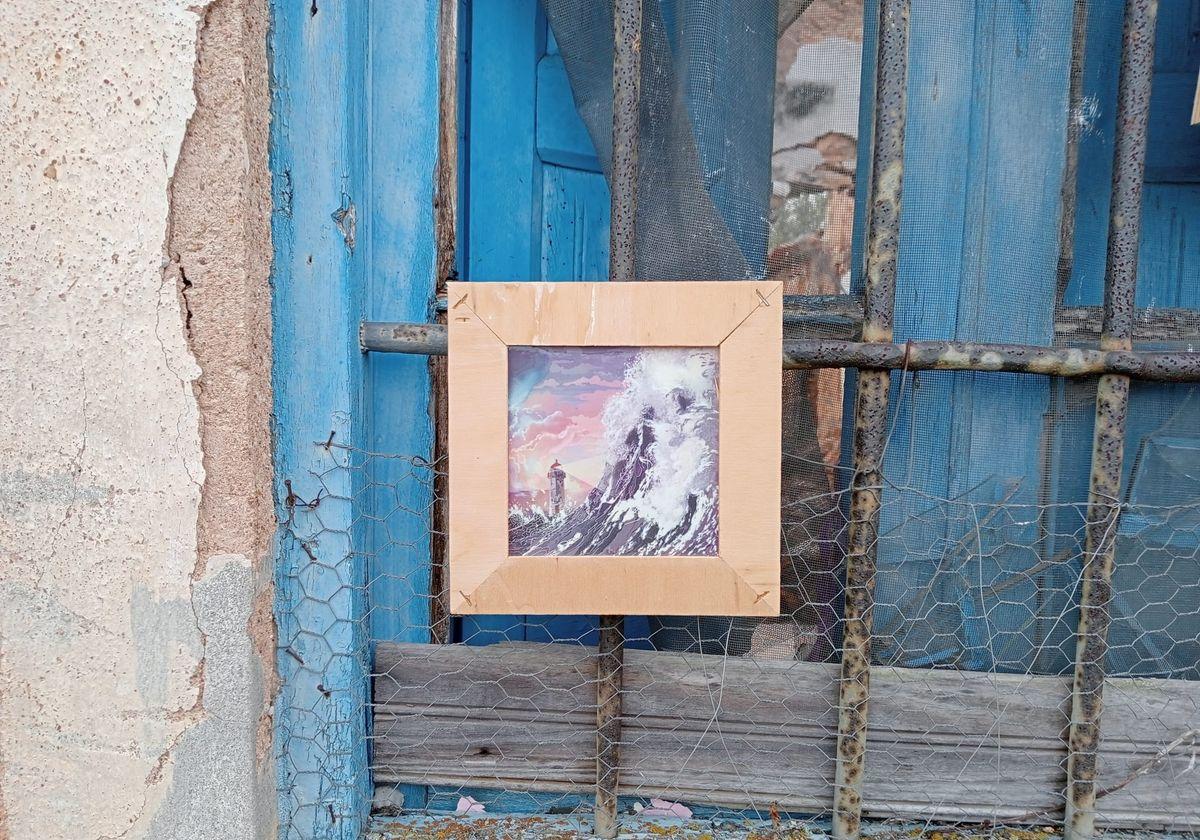 Una de las obras expuestas en la muestra colgada de una ventana.