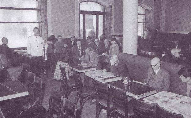 Varias personas leyendo y charlando en el Café Nacional de León.