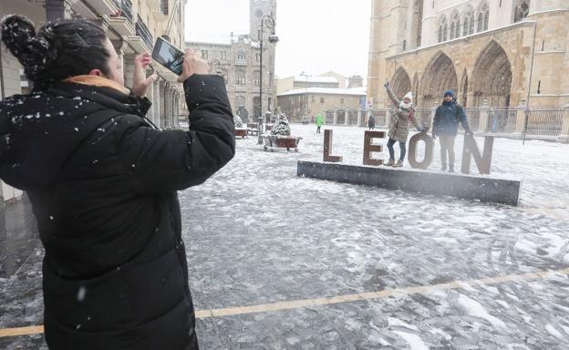 Galería. Una joven toma una fotografía de un grupo de amigos en la Plaza de Regla. 