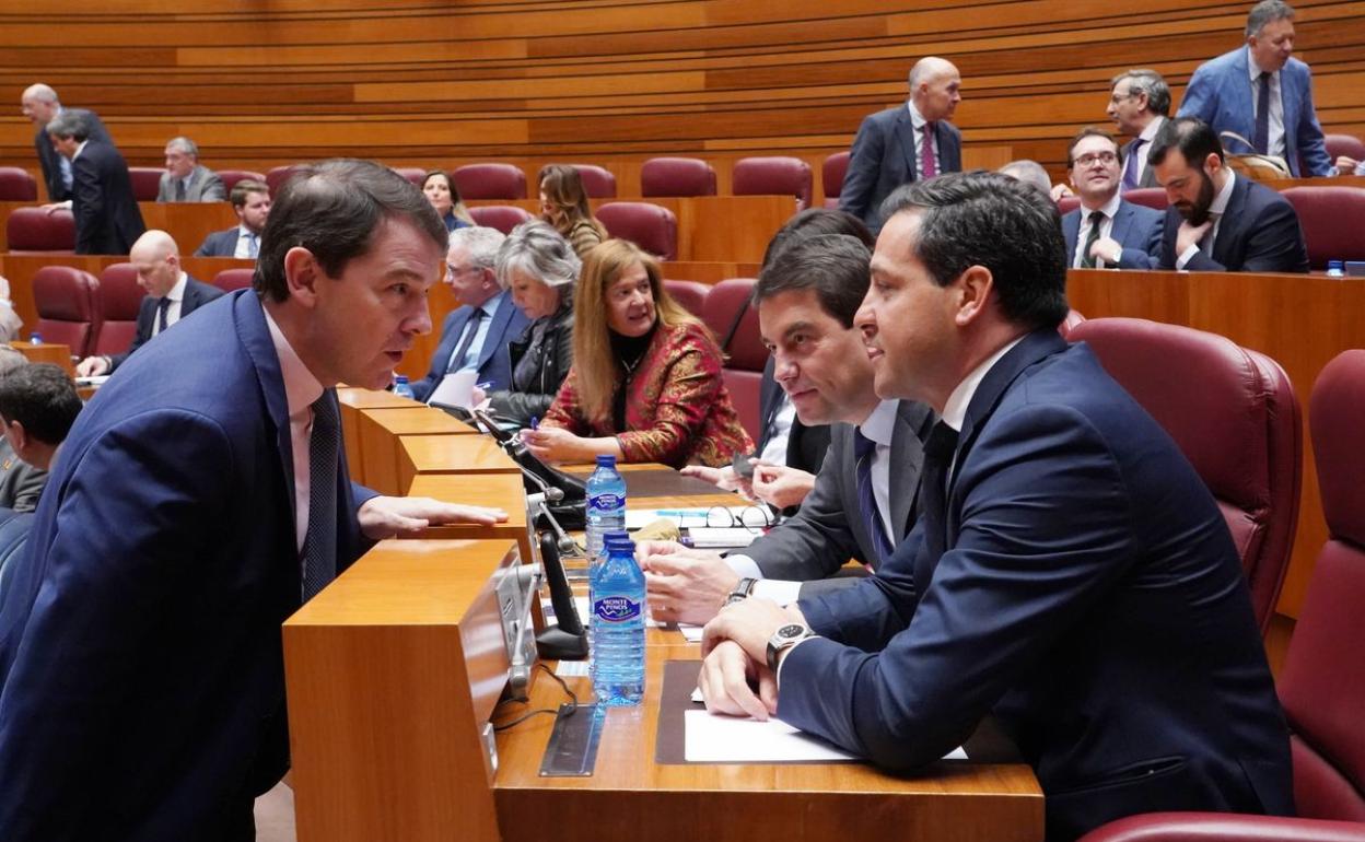 El presidente de la Junta Alfonso Fernández Mañueco conversa con los viceportavoces parlamentarios Raúl de la Hoz y Ángel Ibáñez en el Pleno extraordinario de las Cortes