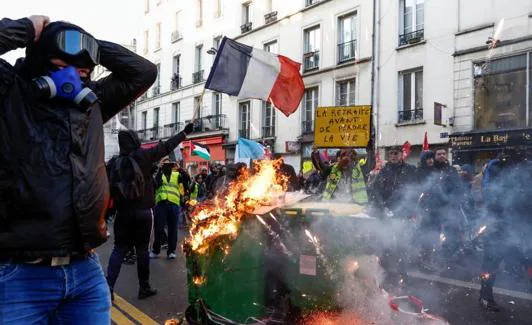 Contenedores de basura en llamas durante una protesta convocada este sábado por organizaciones juveniles en París. 
