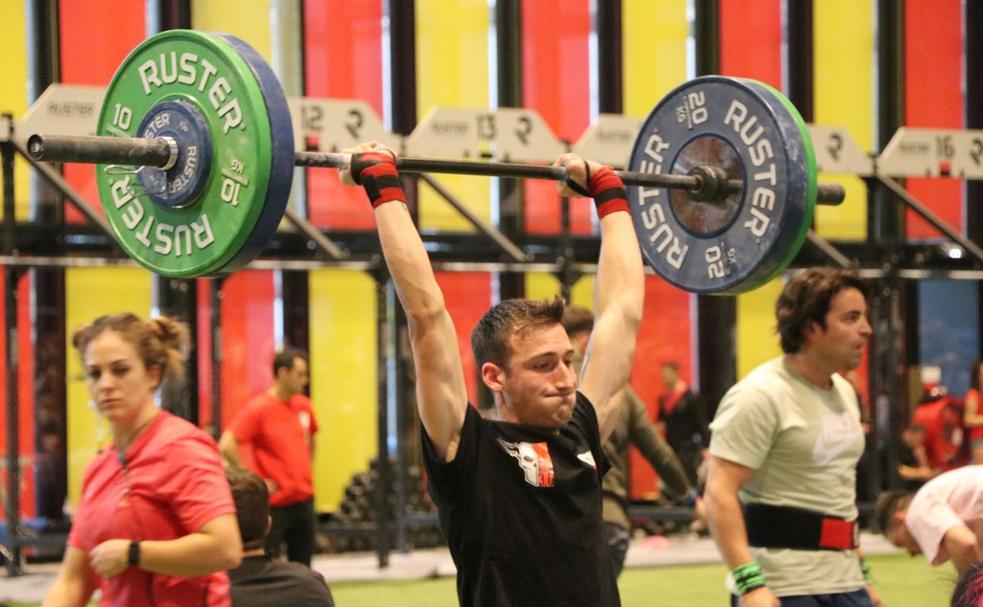 Un joven levanta una pesa de gran tonelaje durante los ejercicios del February Fitness de León.