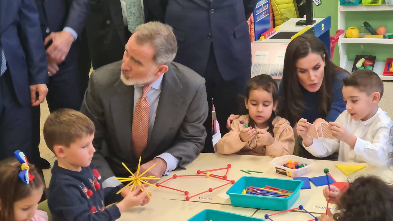 El rey Felipe VI y la reina Letizia saludan y charlan con algunos de los alumnos del centro premiado. 