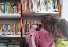 Iván junto a su hermana mirando libros en el bibliobús.