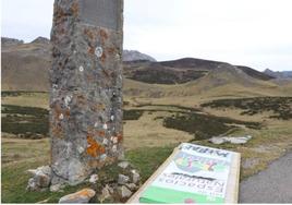 Monolito del alcalde que adquirió los puertos de Pinos y un cartel de la Junta de Castilla y León tirado en el suelo, en el alto de la Cubilla.