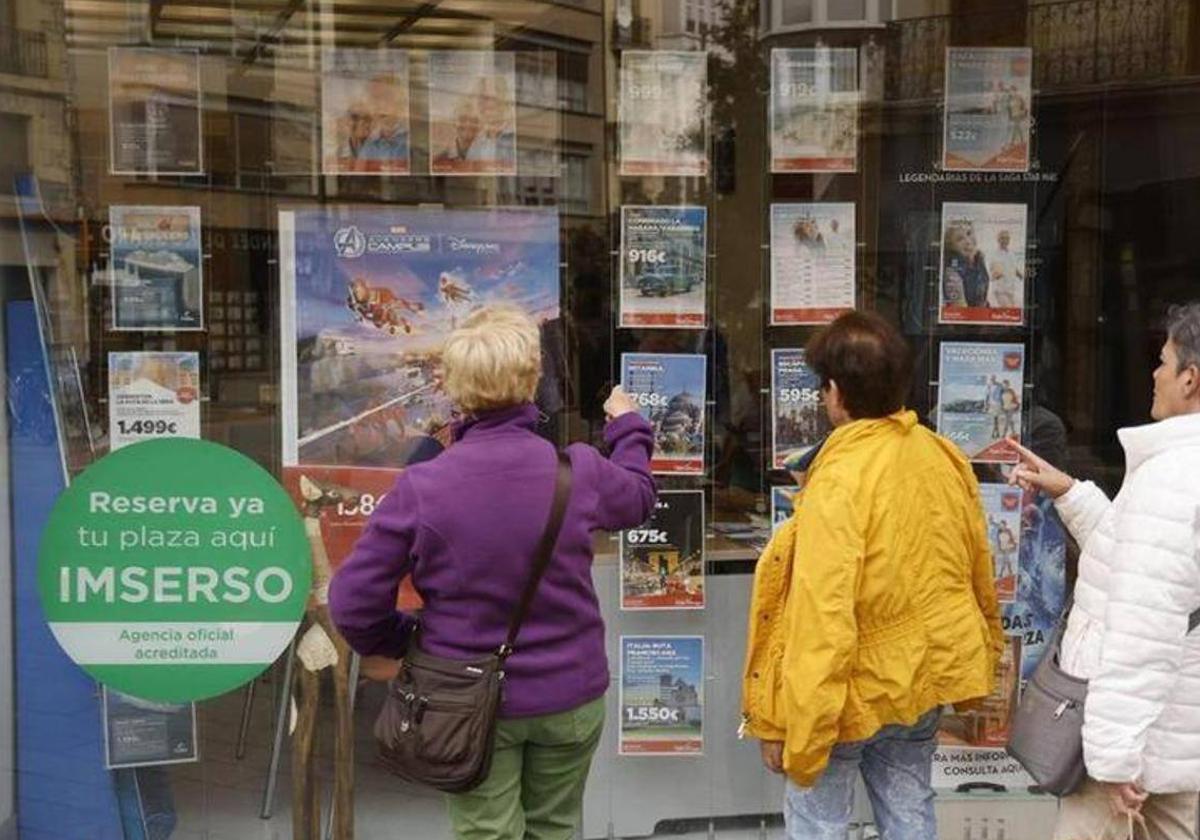 Tres mujeres miran la oferta de viajes del Imserso.