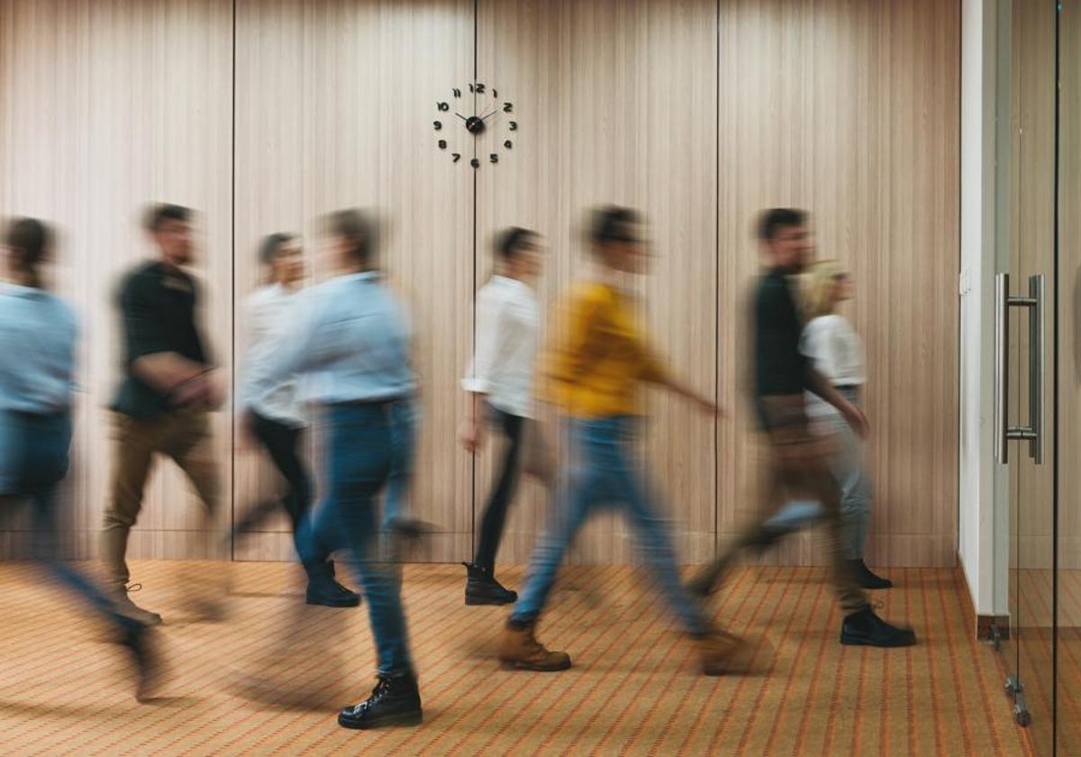 Trabajadores entrando en una oficina.