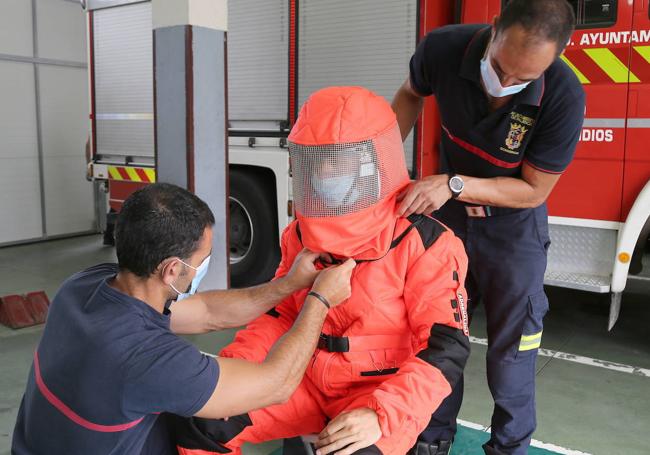 Colocación de un traje de protección para la retirada de enjambres a un bombero.