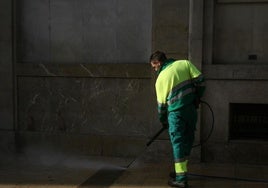 Trabajador del Servicio de Limpieza, limpiando una calle con agua a presión.