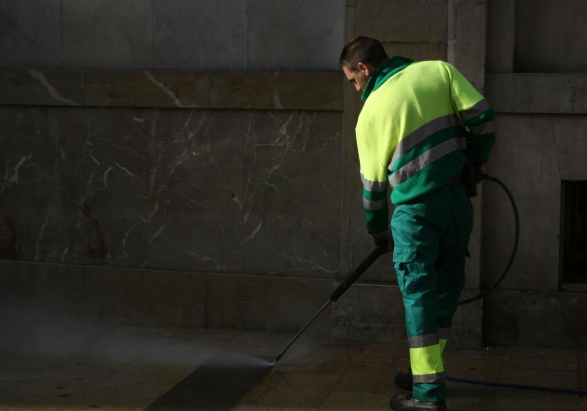 Trabajador del Servicio de Limpieza, limpiando una calle con agua a presión.