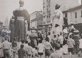 Niños acompañan a los gigantes y cabezudos durante las fiestas por el barrio de Santa Ana.